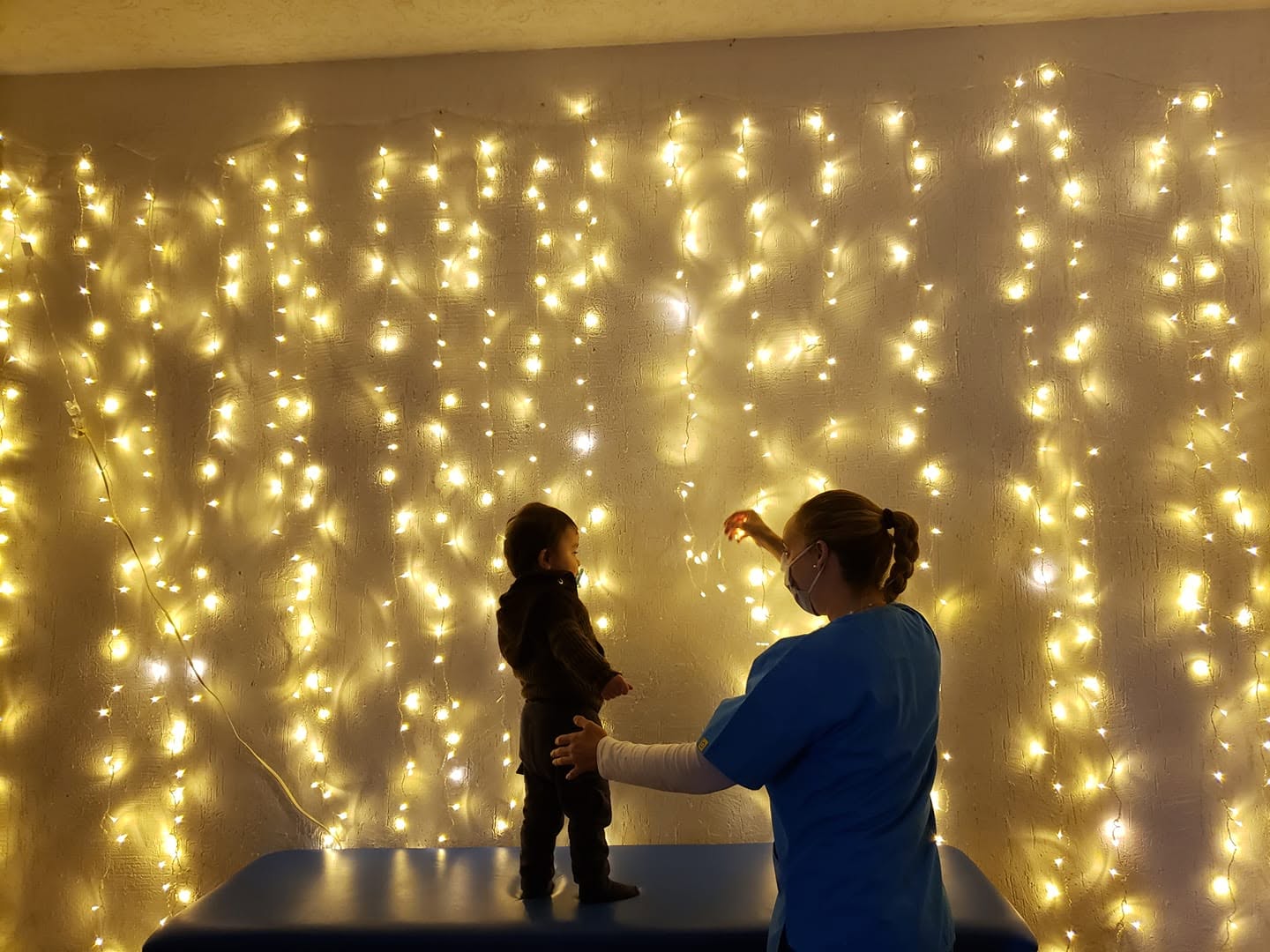 Marcela con un niño en sala multsisensorial viendo unas luces